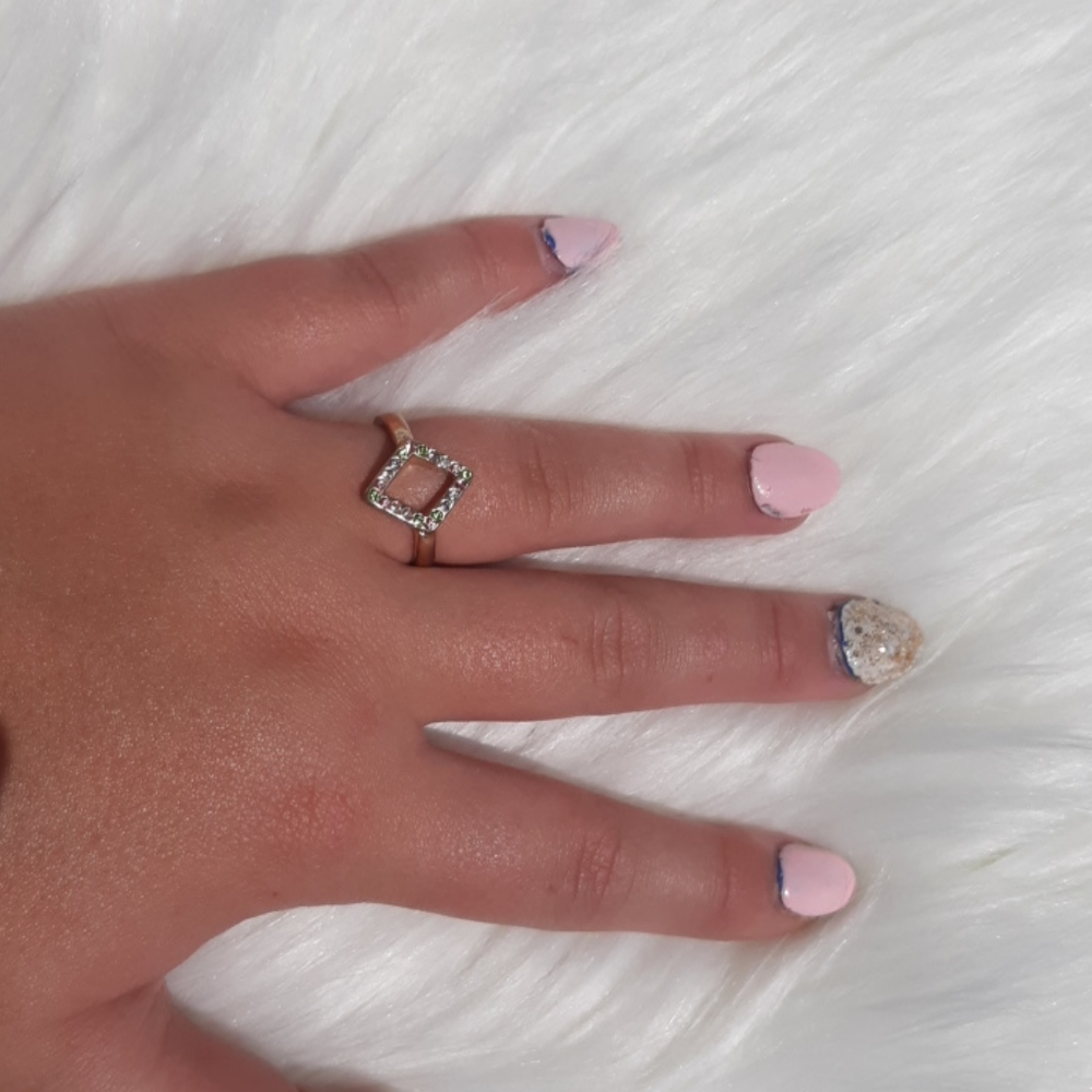 A light pink, light green, and white gem ring.